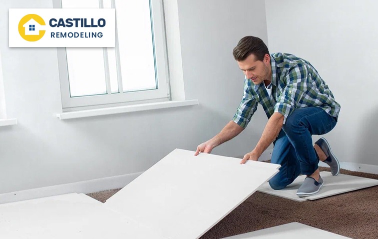 Installer working on placing water-resistant backer board on floor