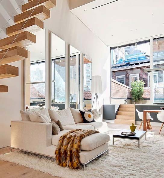 Elegant living area with high ceiling and staircase – home transformation by Castillo Remodeling